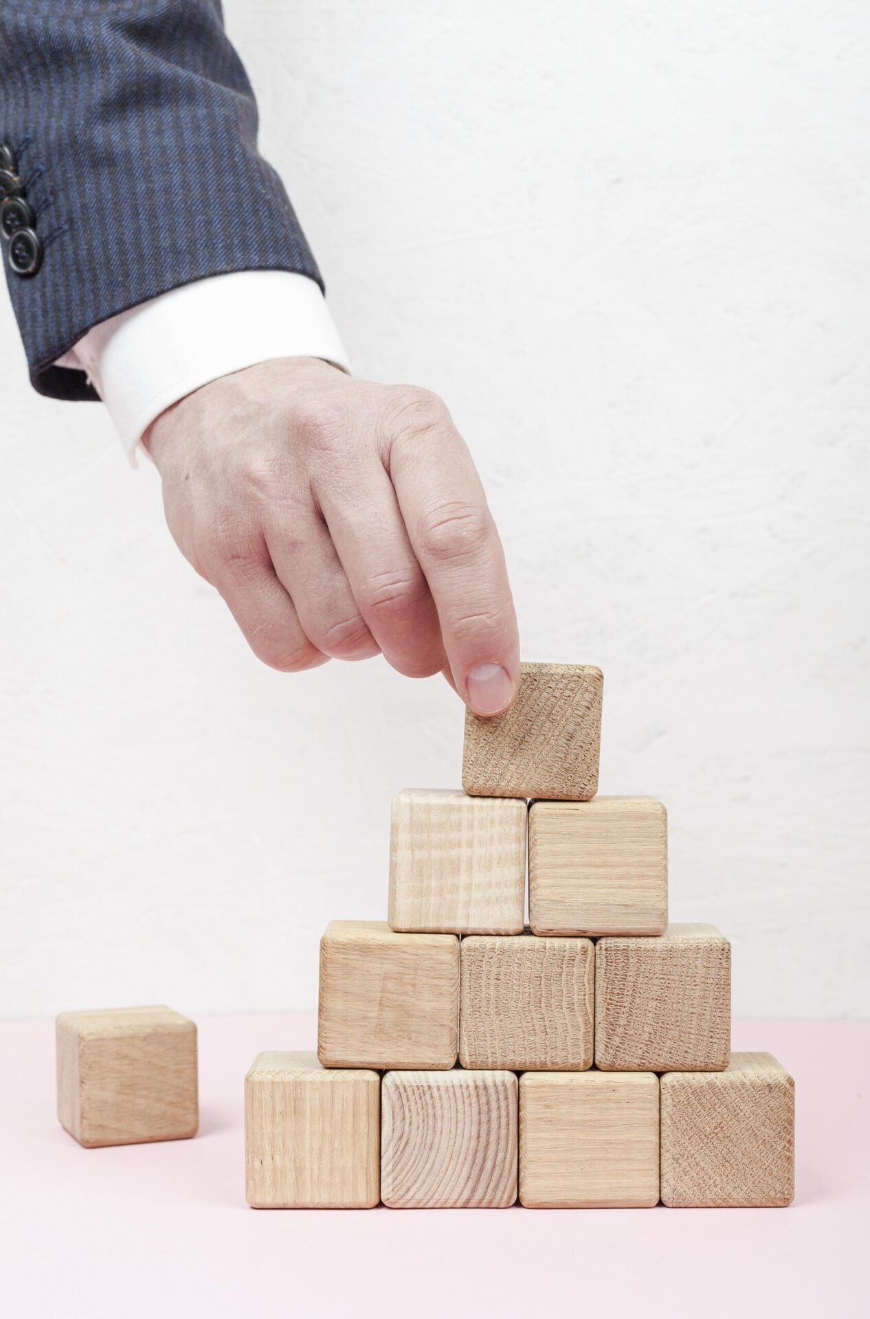hand-creating-pyramid-from-wooden-cubes